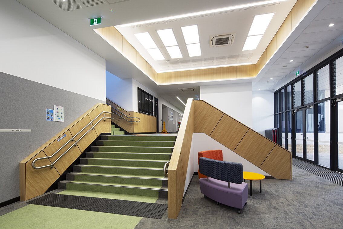 Completed education fit-out with a timber-lined staircase and custom joinery